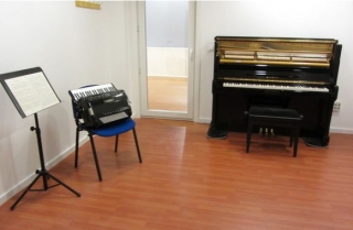 piano de cola y minipiano junto a un atril